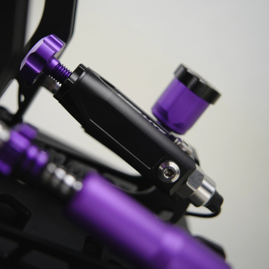 Conspit CPP Lite hydraulic 3 pedal set, extreme close-up — purple hydraulic pressure adjustment knob